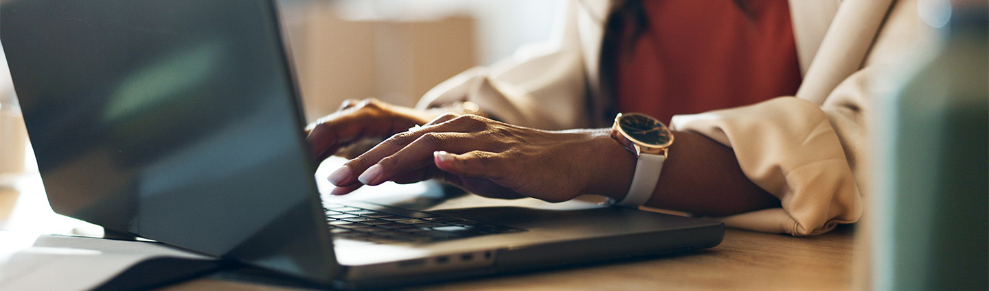 Woman's hands typing on laptop